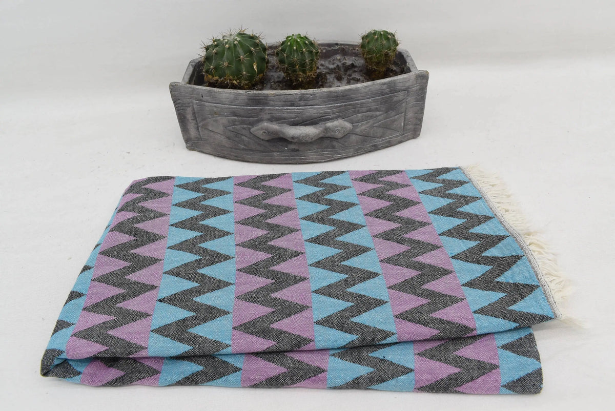 Folded organic bath towel with bold blue purple gray zigzag pattern perfect for beach use