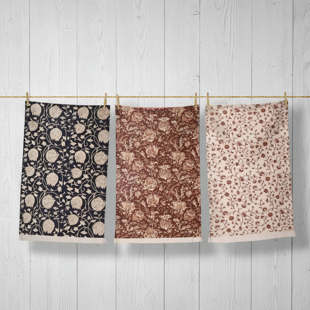 Colorful block print tea towels with floral patterns hanging on a line for a cozy kitchen look