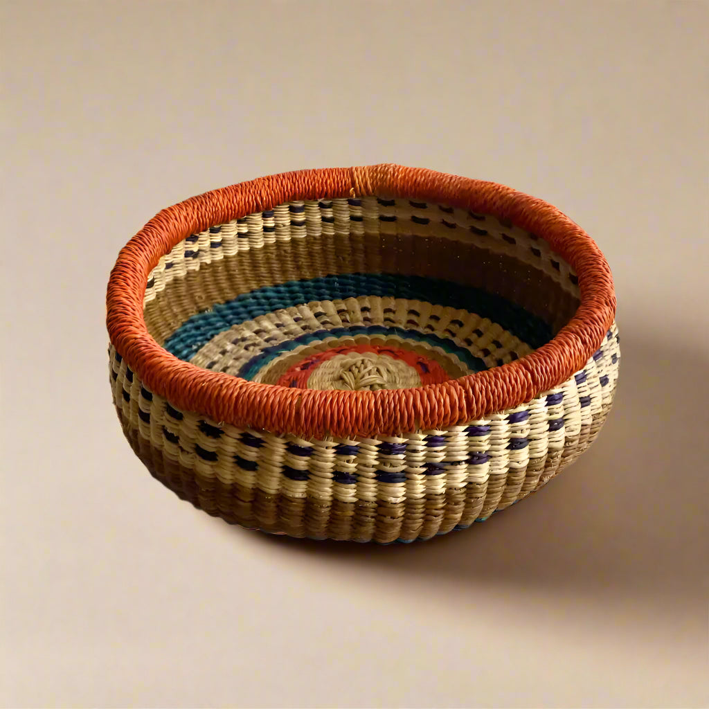 Colorful round Bolga basket with orange rim from Rookery Home, locally harvested fibers