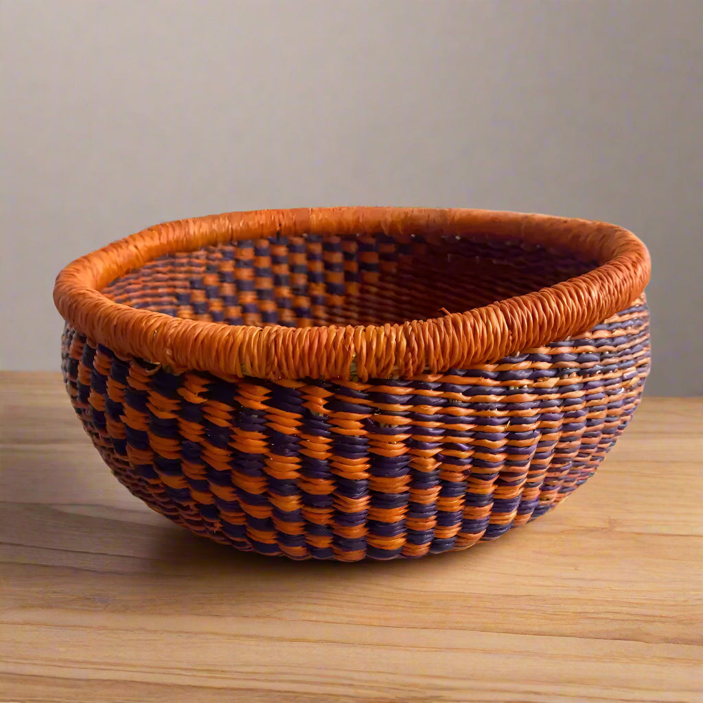 Round Bolga basket with orange and purple stripes from Rookery Home, locally harvested fibers