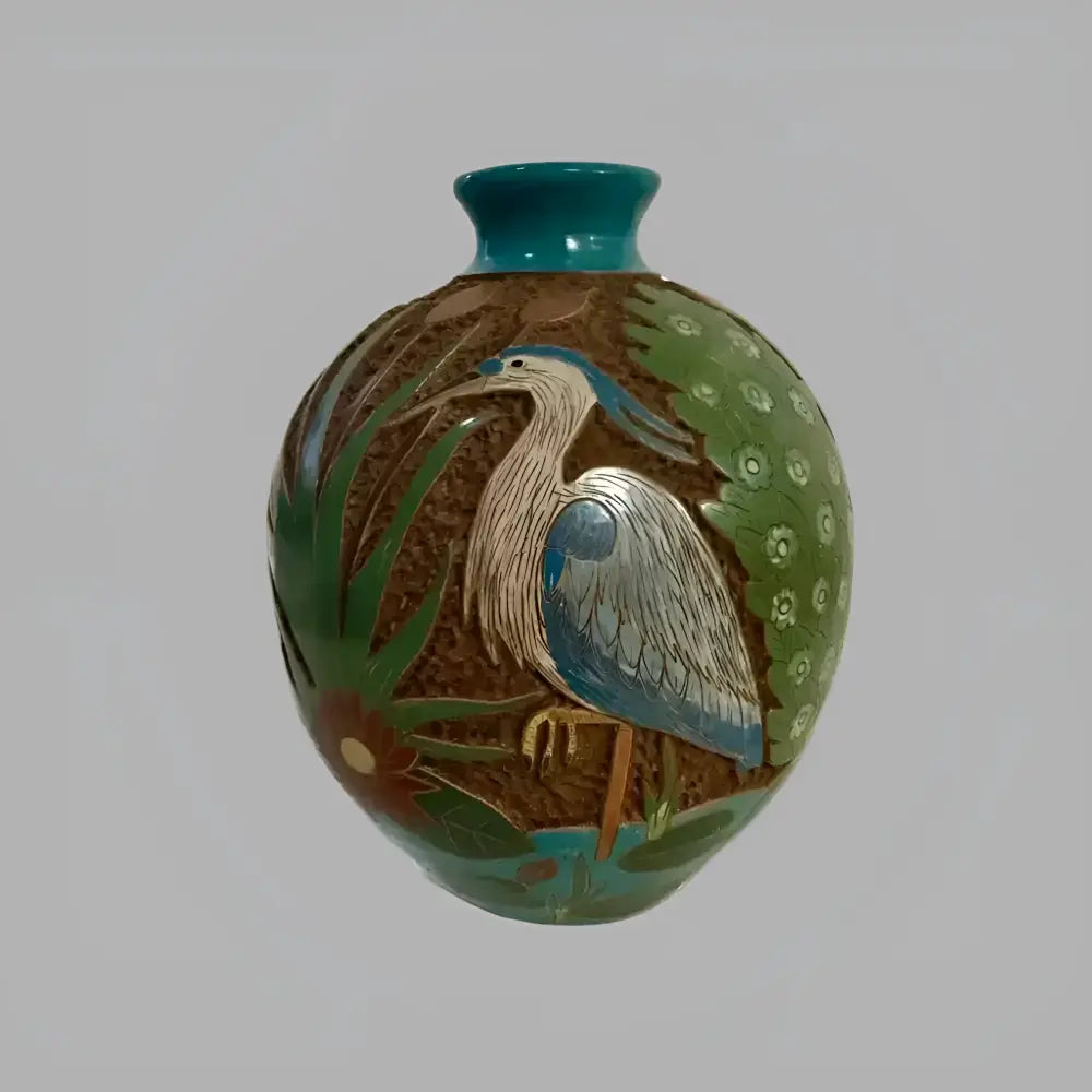 Ornate carved clay heron vase with nature motif and textured clay beneath