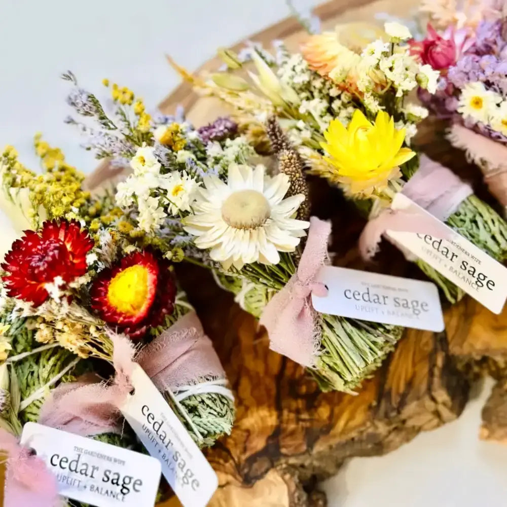 Cedar sage bundle wrapped in soft pink ribbon with white tags for smoke cleansing and grounding energy
