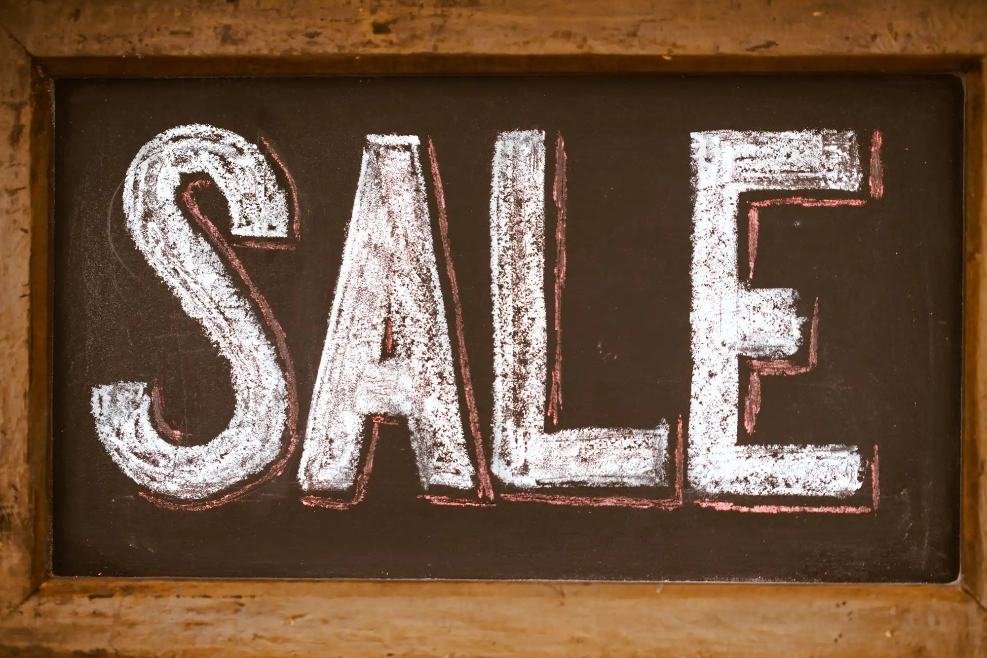 Chalkboard sign with ’SALE’ written in white chalk