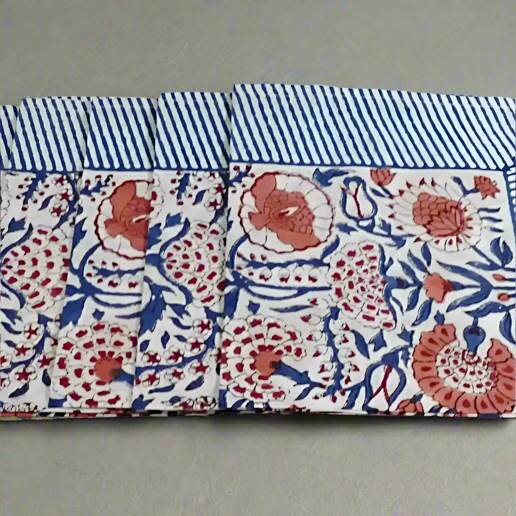 Cotton block print napkins with white fabric, blue stripes, and coral floral patterns