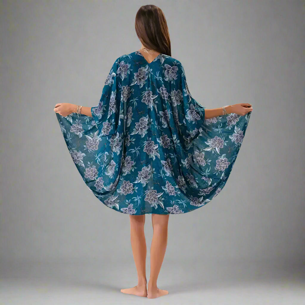 Woman wearing teal floral kimono cover up, perfect for summer beach vibes