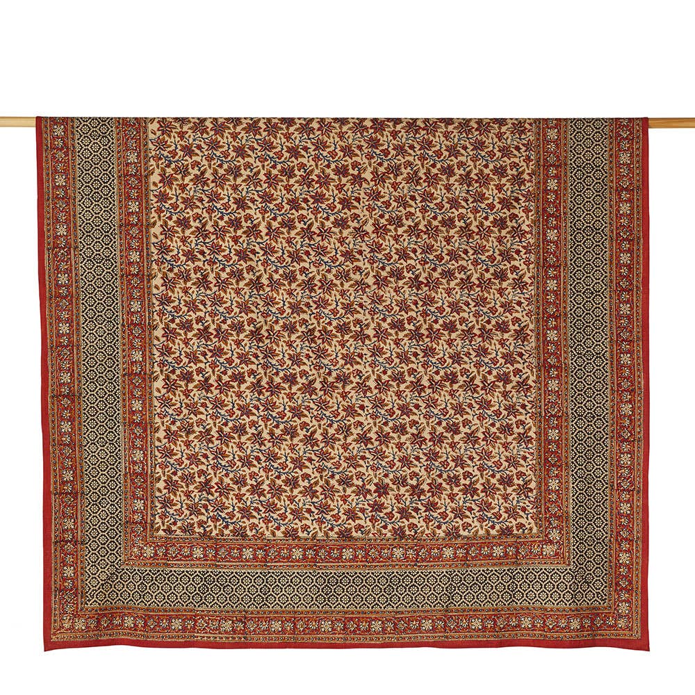 Rust and black multicolor printed tablecloth hanging on a rod.