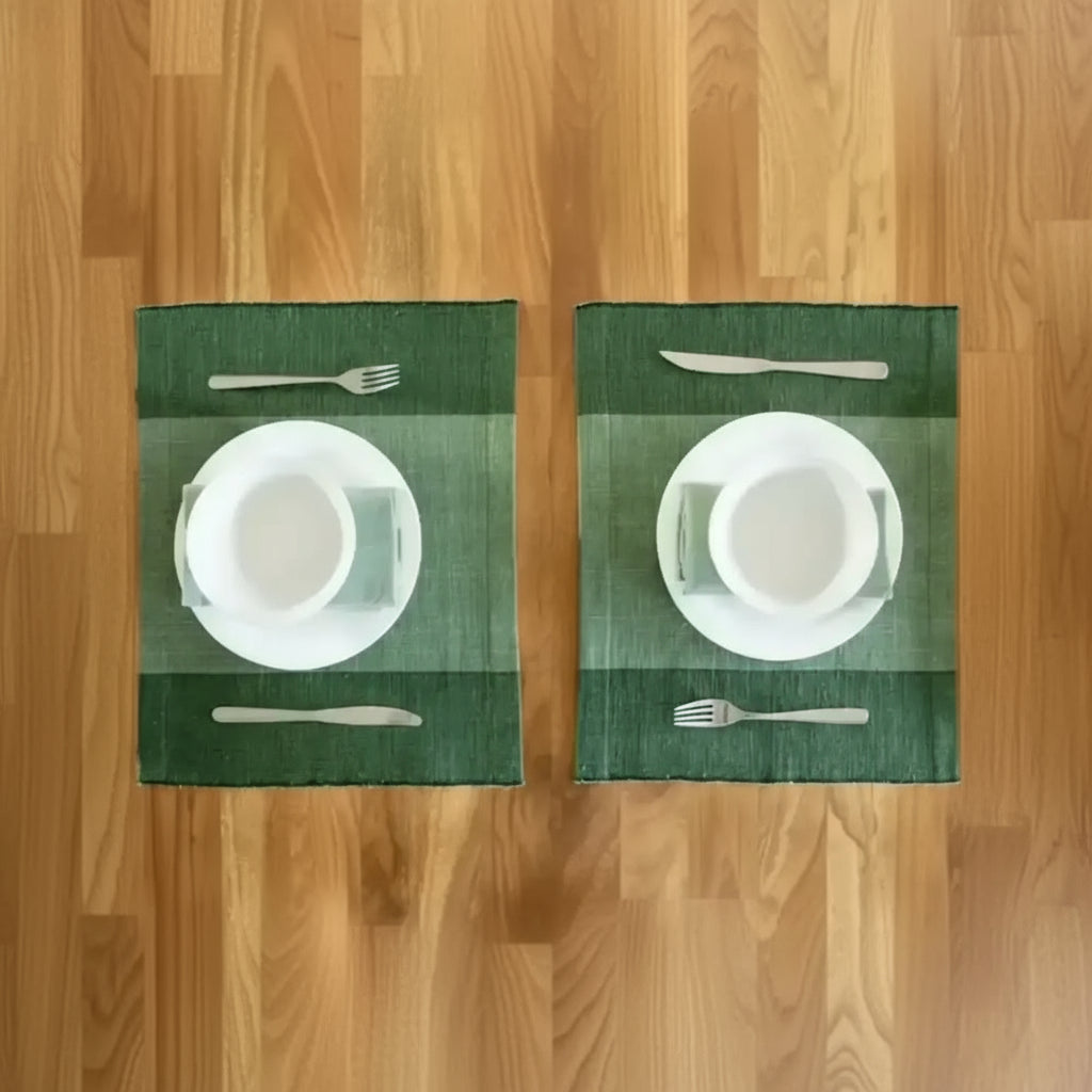Green Ethiopian cotton table runner with two neatly set placemats and white dinnerware