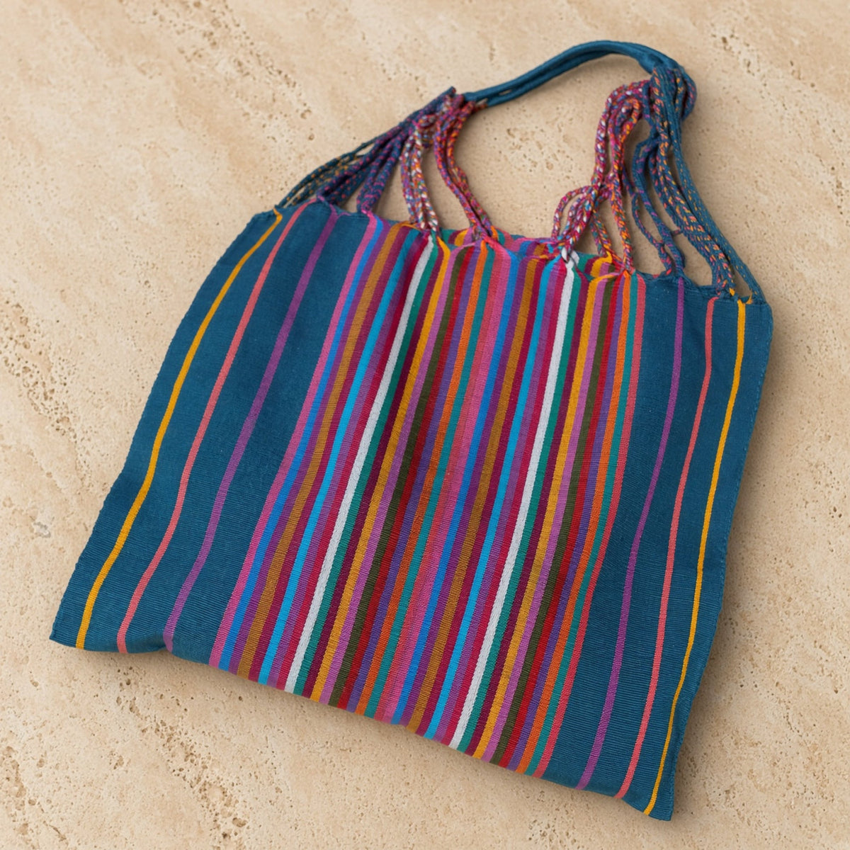 Vibrant hammock tote bag handwoven by mayan artisans in blue pink orange with braided handles and colorful stripes