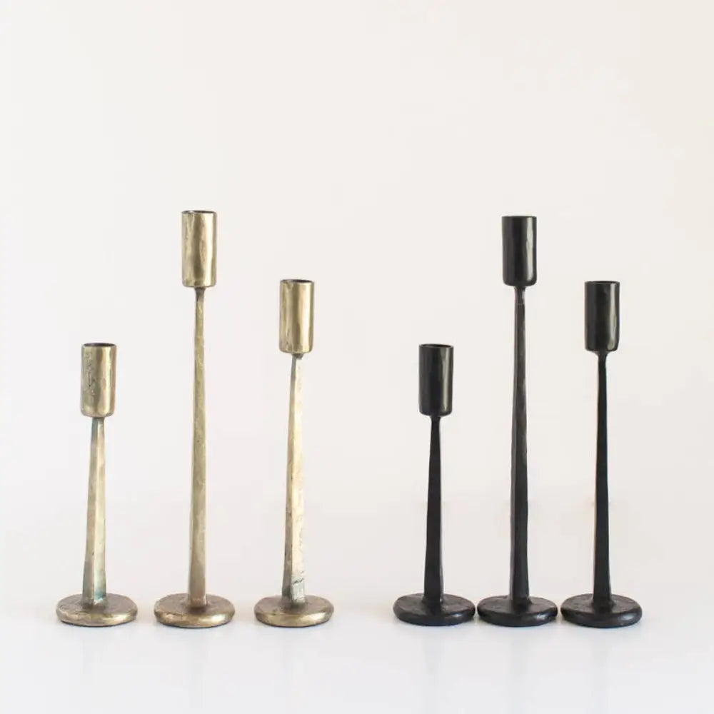 Hand Forged Iron Candle Standsthree black and three brass on a white surface