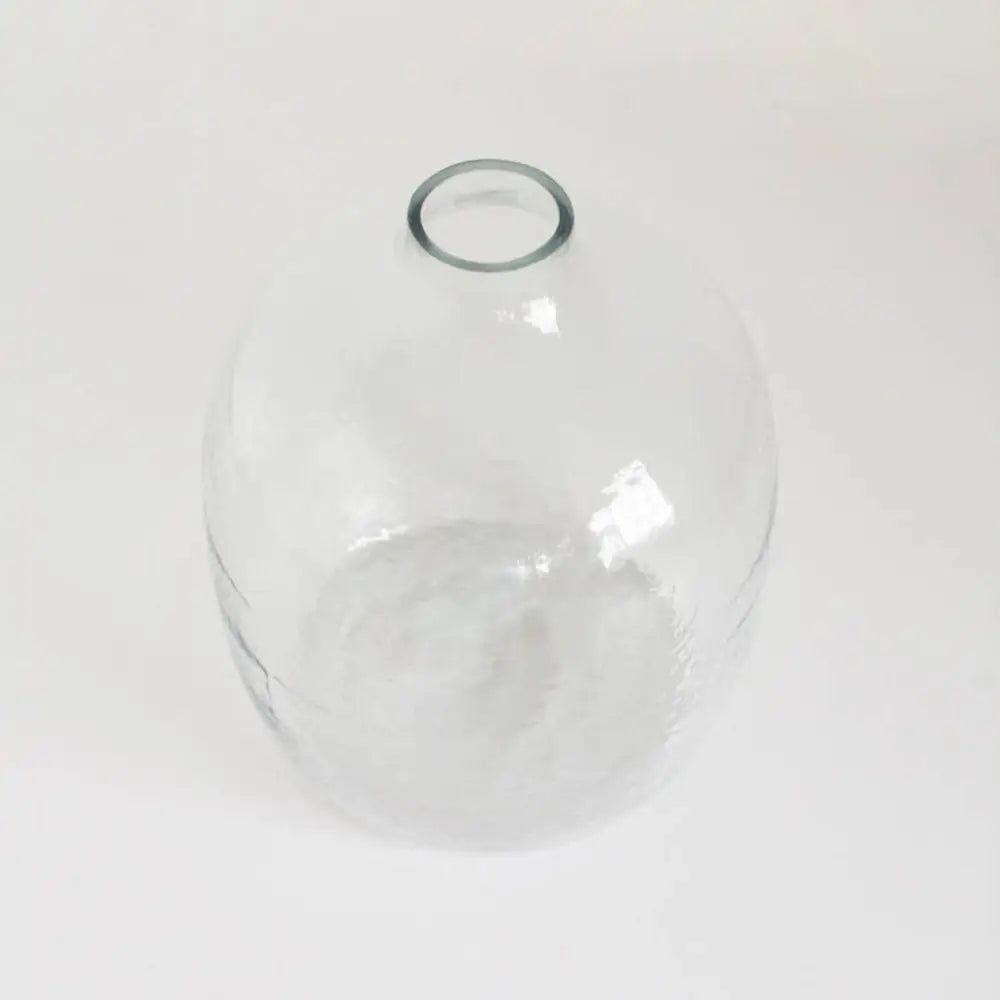Handblown hammered glass vase above view on light background.