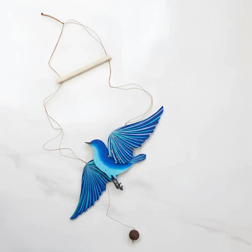 Handcrafted blue bird flying mobile with vibrant blue wooden bird, layered wing details, and a hanging brown bead