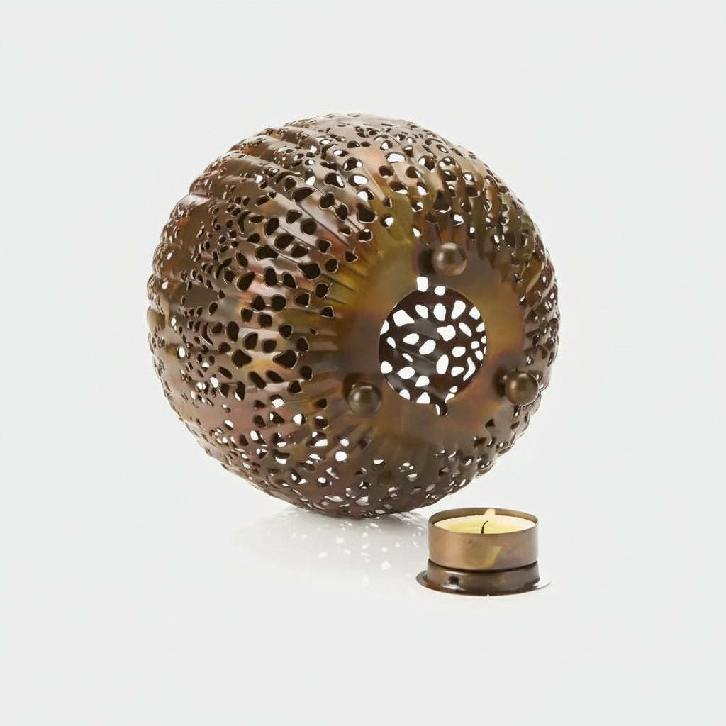 Handmade eco-friendly bronze sea urchin-shaped candle holder with perforations and a central opening