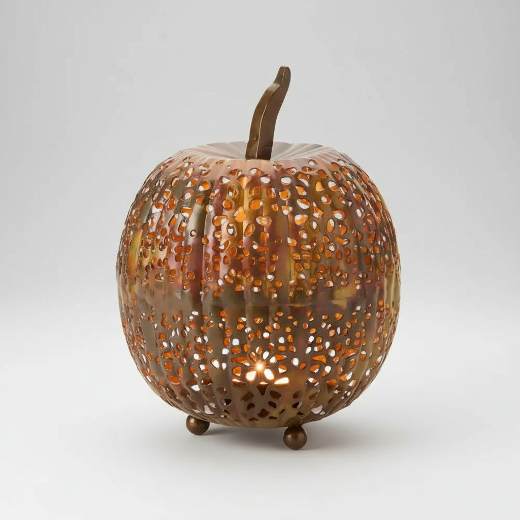 Copper-colored handmade eco-friendly metal pumpkin lantern with intricate perforations and flame