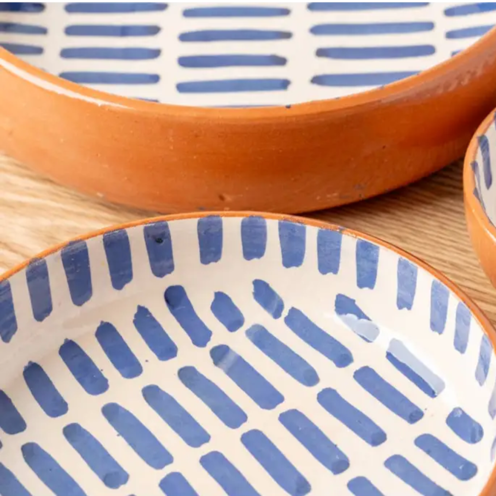 Three handmade nested Moroccan ceramic bowls with blue and white striped patterns
