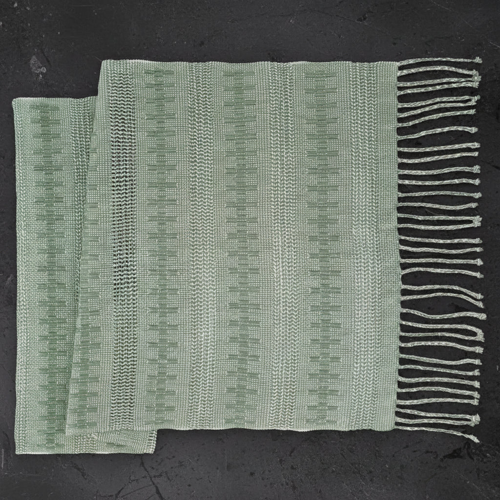 Light green handcrafted calado table runner with vertical stripes and fringe detail