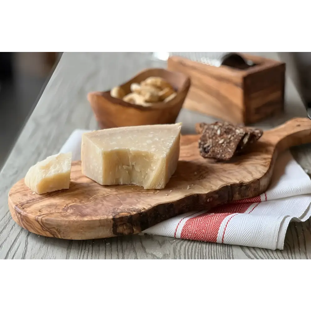 Italian Olivewood Charcuterie and Cheese Paddle Board with food on it