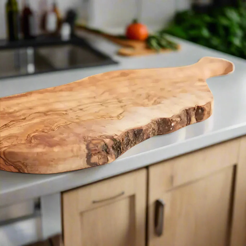 Italian Olivewood cutting board with bark edge and paddle handle for rustic style