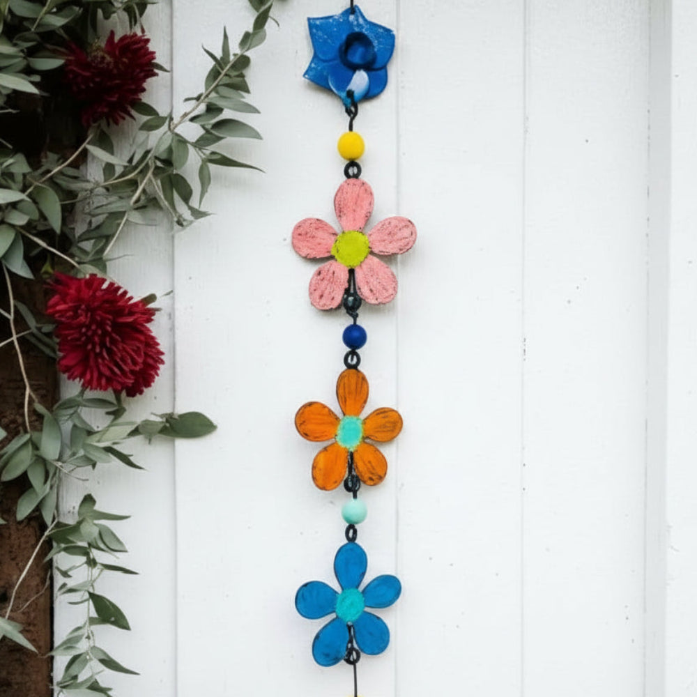 Colorful metal flower wind chime with pink, orange, blue blooms and golden bell