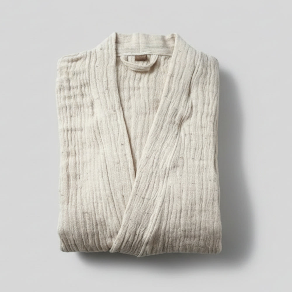 Folded off-white muslin bathrobe in cotton nope yarn with crinkled texture