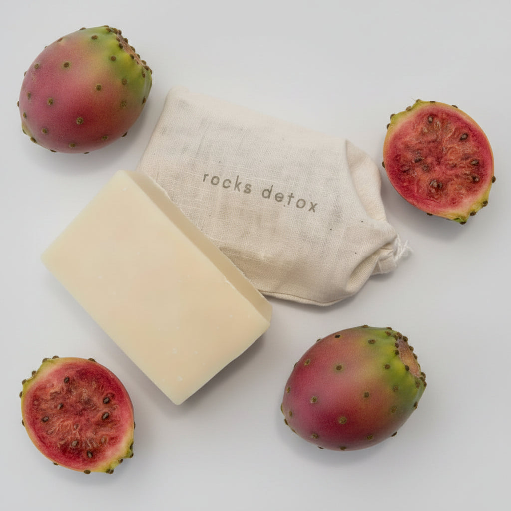 Organic shea butter soap with cactus pear beside rocks detox bag and citrus slices