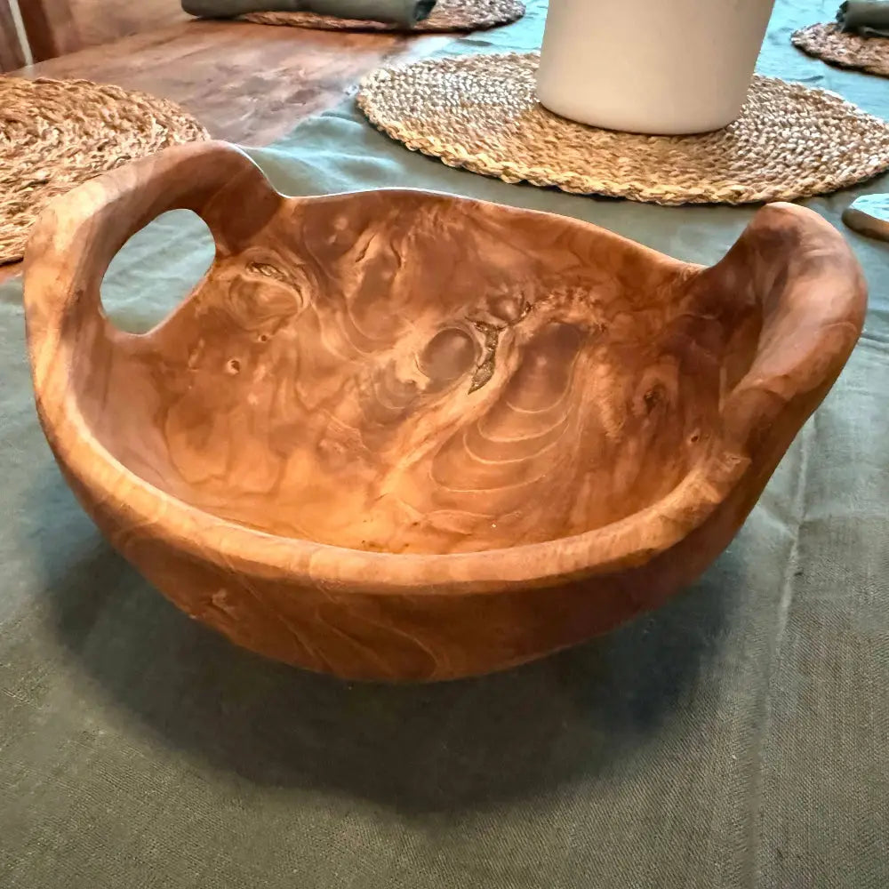 Rustic teak bowl with handles showing natural grain patterns perfect for home decor or serving
