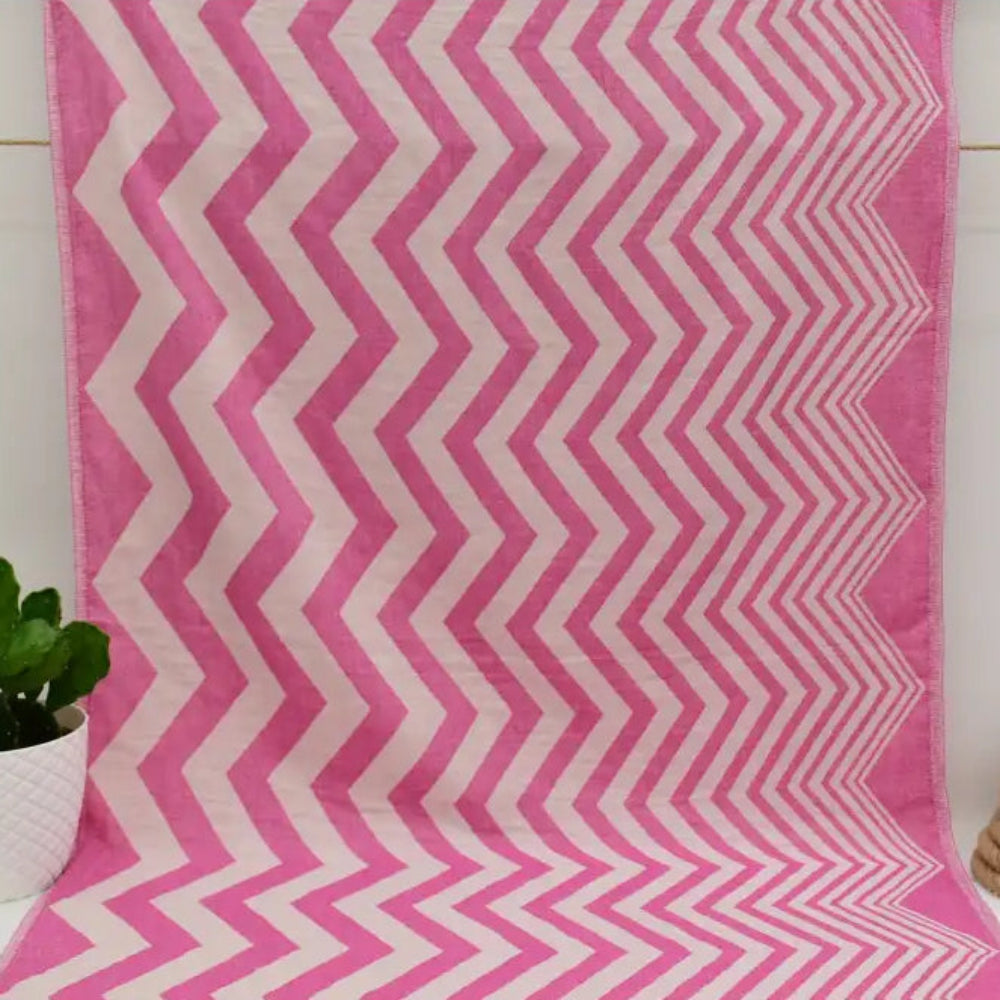 A pink and white zigzag pattern peshtemal towel made of soft textured fabric perfect as a turkish towel