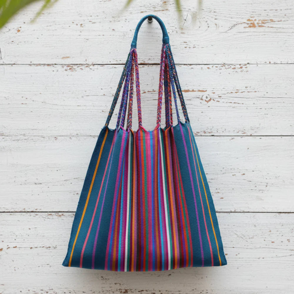 Vibrant striped woven tote bag with braided handles in teal, pink, orange, and purple.