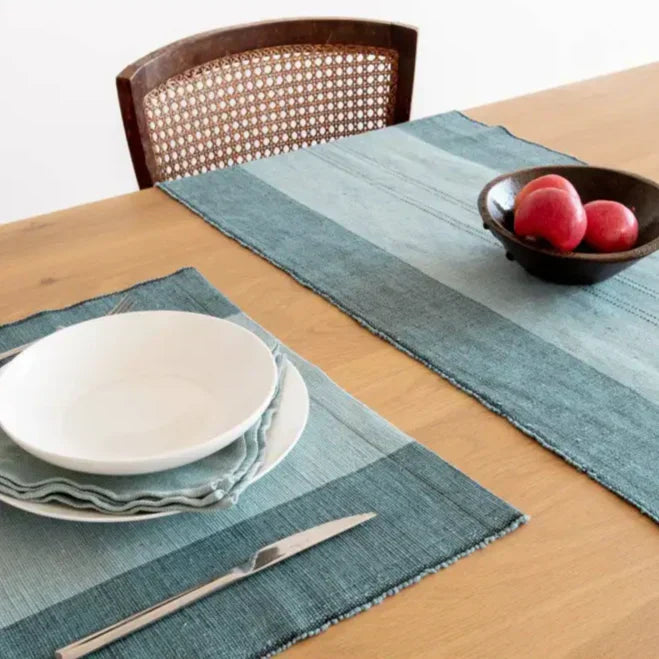 Set table with blue striped placemats and matching table runner from the Handwoven Ethiopian Cotton Collection Cedar