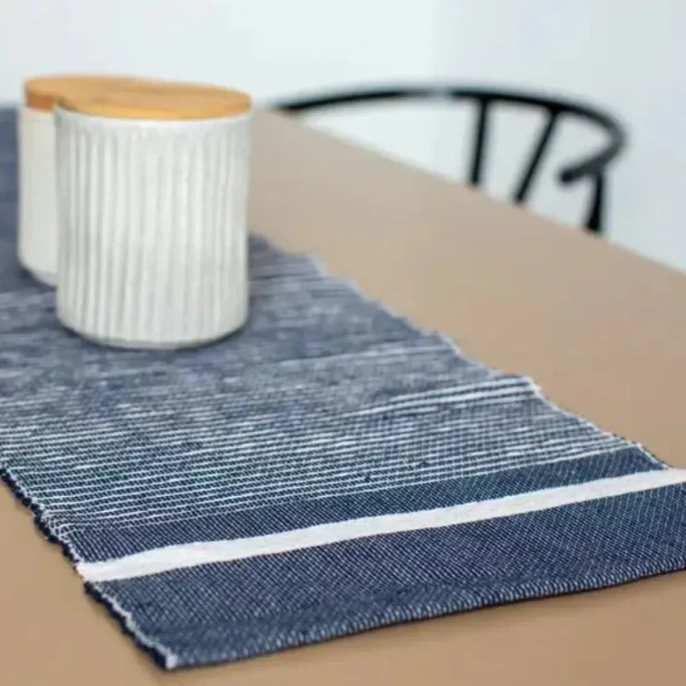 White ceramic canisters with wooden lids on a striped Blue Table Runner from Ethiopia