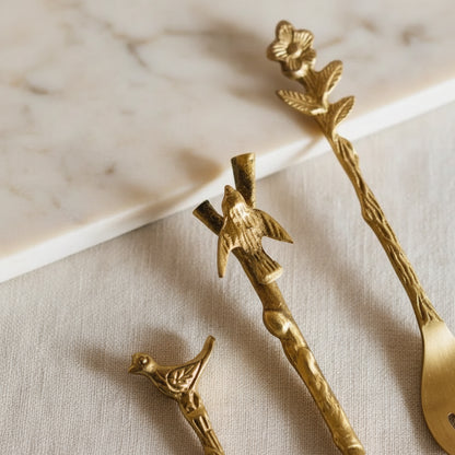 Gold bird and branch tassel necklace on Adavi Brass utensils