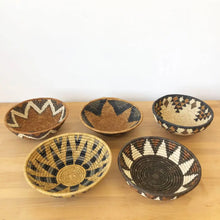 Assorted handmade African baskets in various natural colors with striking geometric designs.