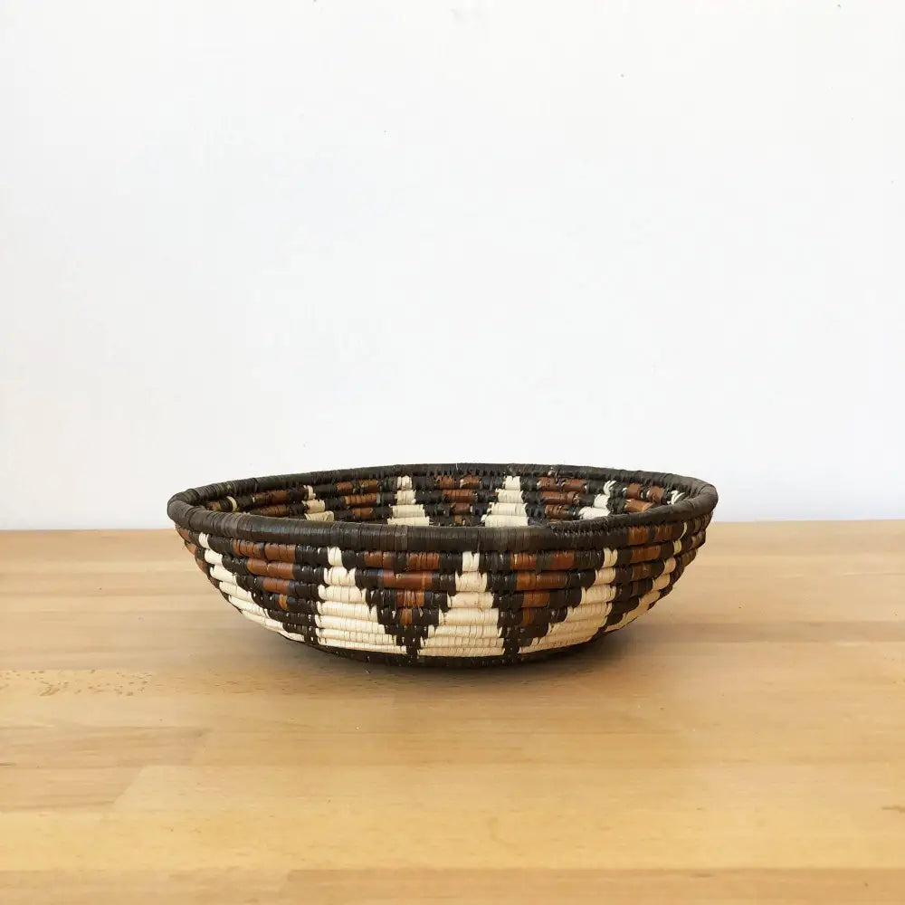 Assorted handmade African baskets in various natural colors with striking geometric designs.