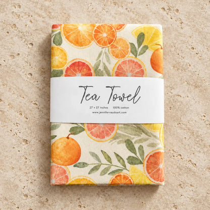 Artisan tea towel with vibrant citrus fruit design of sliced oranges lemons and grapefruits on off-white pre-washed flour sack