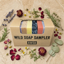 Beige cardboard wild soap sampler box with a clear window showing five colorful artisanal wild soap bars in certified organic gift box