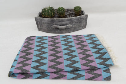 Folded organic bath towel with bold blue purple gray zigzag pattern perfect for beach use