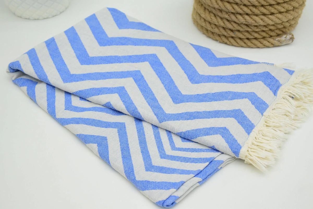 Folded turkish towel with zigzag design pale sax blue pattern and cream fringe perfect for beach or bath use