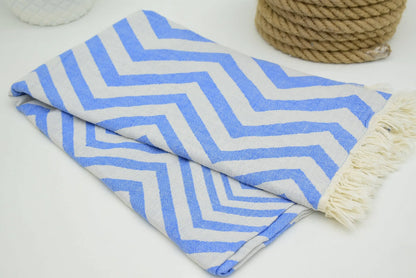 Folded turkish towel with zigzag design pale sax blue pattern and cream fringe perfect for beach or bath use