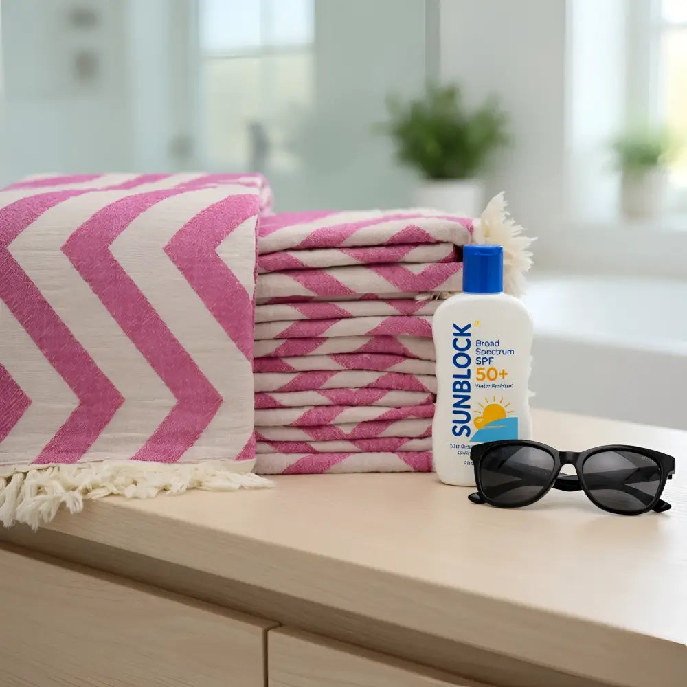 Stack of authentic turkish organic cotton beach towels in pink and cream chevron pattern with fringed edges