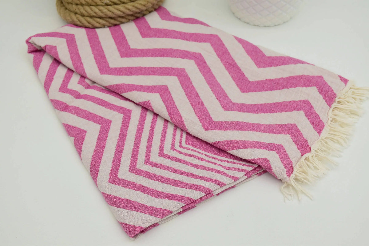 Pink and white chevron pattern peshtemal towel with fringed edges perfect as a lightweight turkish towel