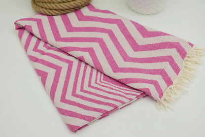 Pink and white chevron pattern peshtemal towel with fringed edges perfect as a lightweight turkish towel