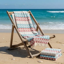 Authentic turkish organic cotton beach towel with vibrant coral pink and light blue zigzag pattern and tassels