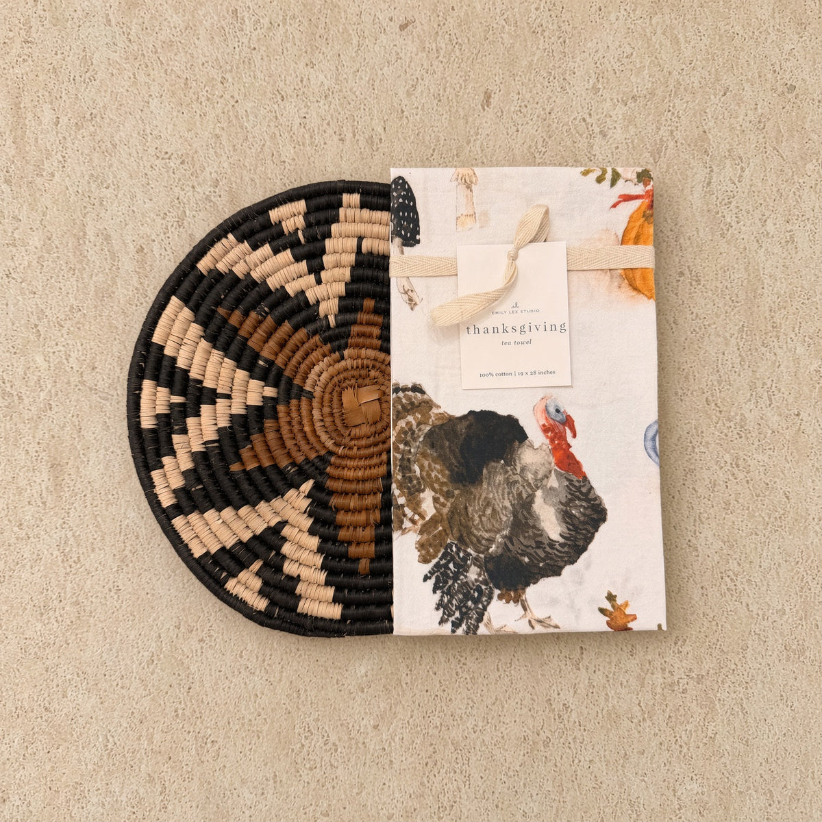 Handwoven african zulu trivet with black beige and brown geometric pattern paired with autumn tea towel