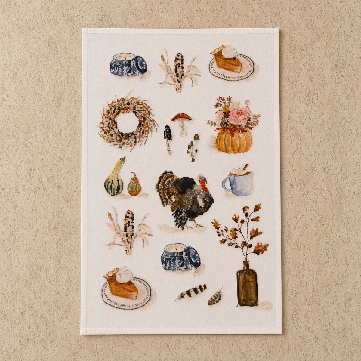 A rectangular autumn tea towel with watercolor turkey pumpkins and pie paired with an african zulu trivet nest