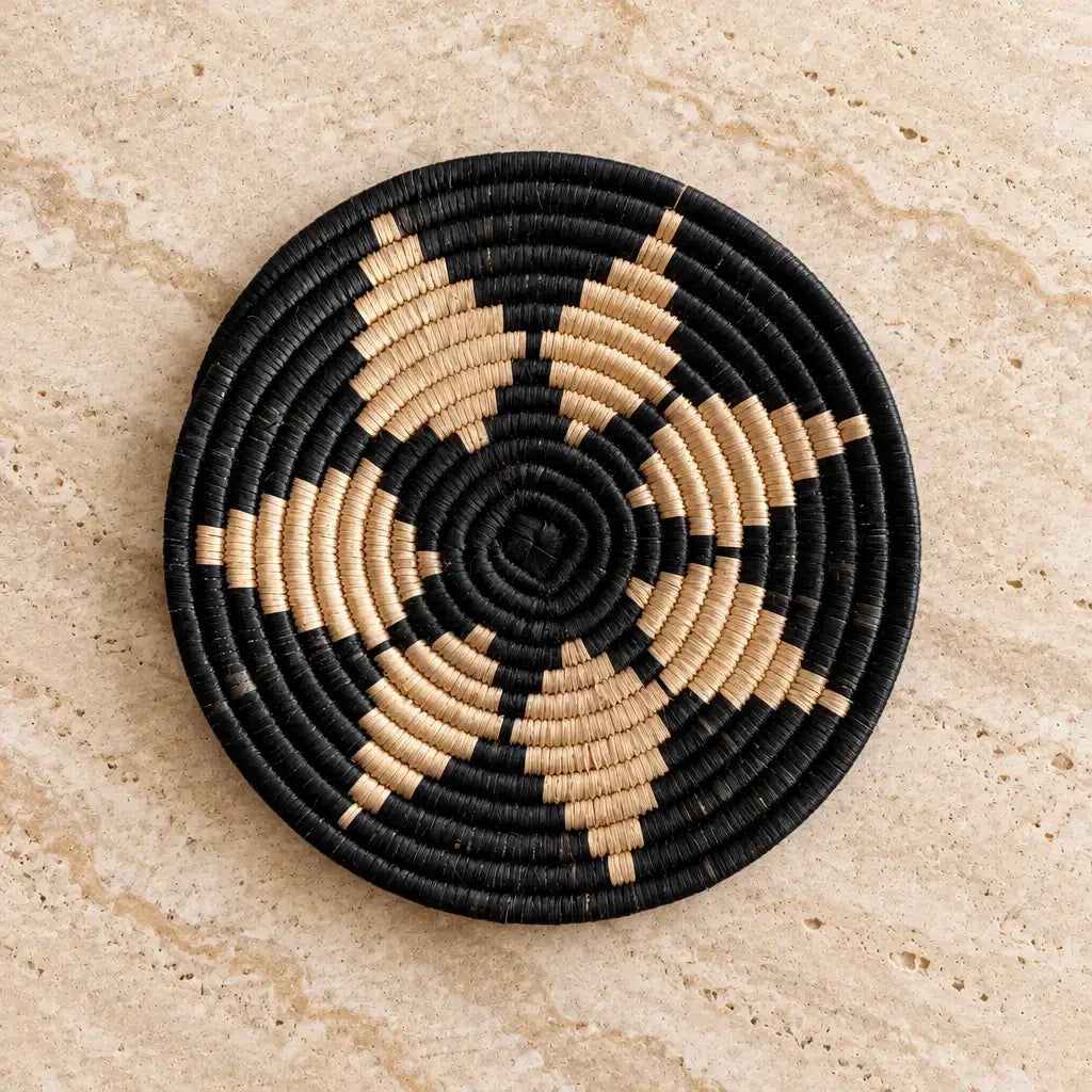 Black and beige woven african zulu trivet with a circular spiral pattern perfect for autumn tea towel use