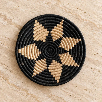 Black and beige woven african zulu trivet with a circular spiral pattern perfect for autumn tea towel use