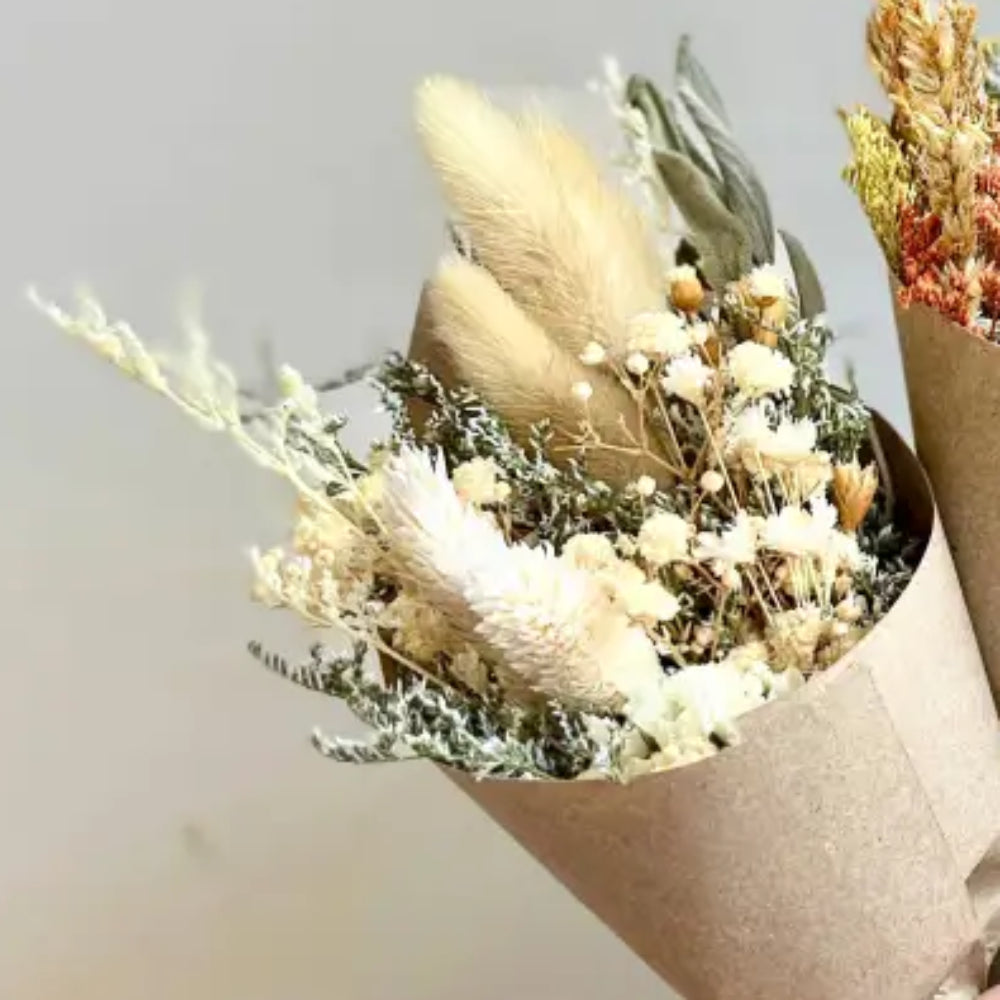 Handmade baby bouquets: three eco-friendly dried flower wraps in kraft paper with beige, orange, blue hues