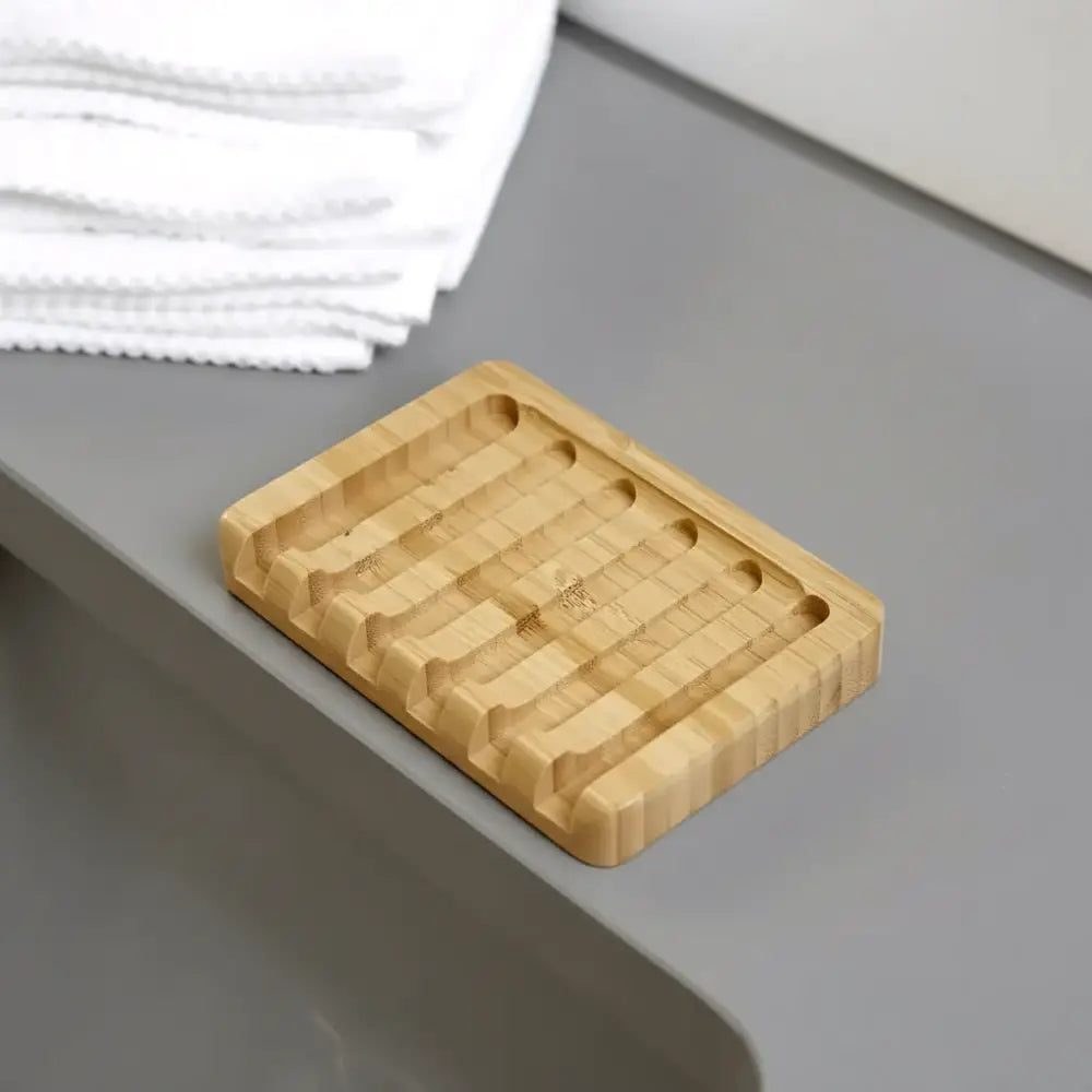 Rectangular bamboo soap lift with natural wood grain and subtle grooves for drainage featuring lattice design allows airflow