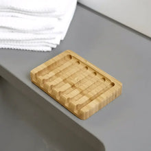 Rectangular bamboo soap lift with natural wood grain and subtle grooves for drainage featuring lattice design allows airflow