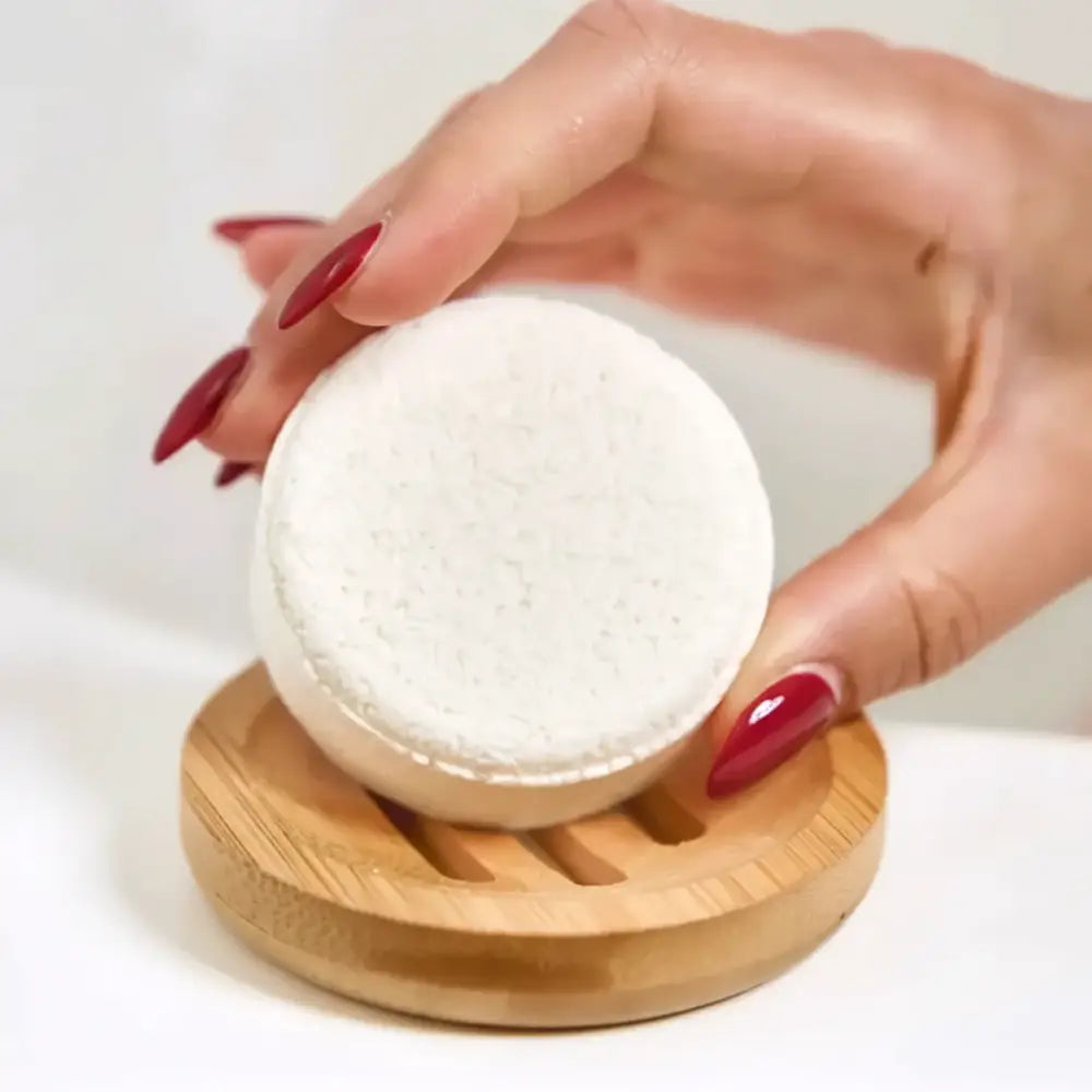 White circular textured bath sponge resting on a wooden soap lift for bamboo shower steamer circle lift use
