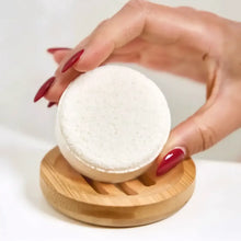 White circular textured bath sponge resting on a wooden soap lift for bamboo shower steamer circle lift use